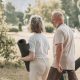 Pareja de personas mayores camina por el parque con esterillas de yoga, disfrutando del estilo de vida activo y consciente que aporta la meditación en personas mayores