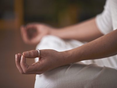 Manos de una persona en posición de meditación, gesto de atención y calma.
