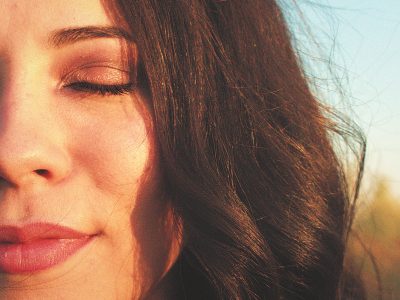 Mujer joven con los ojos cerrados en calma, representando la salud mental y el bienestar interior.