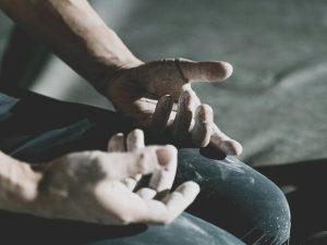 Primer plano de manos curtidas con tiza en postura de meditación Zazen. La disciplina física y la quietud como antídoto contra las distracciones.