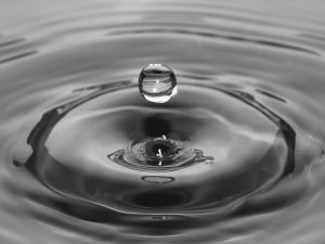 Gota cayendo sobre agua en calma ilustrando la observación pura de las emociones en Anapanasati